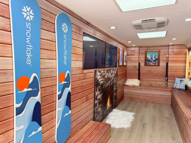 Branded school bus activation for Snowflake featuring a lodge-inspired interior, AV setup, and hospitality service produced in-house by NVS Visuals.