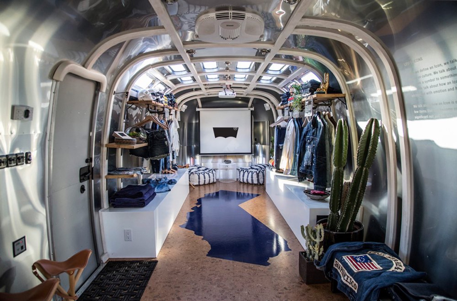 1984 Airstream RV — denim pop-up interior Denim pop-up retail interior in the Airstream RV with hanging garment racks and projector screen