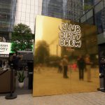 Gold mirror photo wall with Club Dirty Brew by Belvedere logo on Manhattan West Plaza