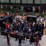 Aerial view of Belvedere Club Dirty Brew activation at Manhattan West Plaza with crowd, bar truck and gold mirror wall