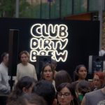 Crowd in front of the Club Dirty Brew neon sign wall