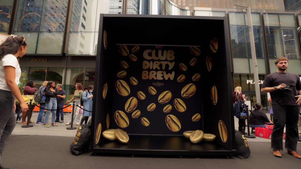 Walk-in photo booth with oversized gold coffee beans and Club Dirty Brew logo Walk-in photo booth with oversized gold coffee beans and Club Dirty Brew logo
