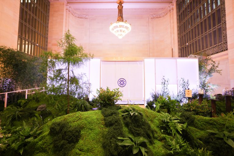 Moss hillside and plexiglass tea pavilion beneath the Vanderbilt Hall chandelier, Grand Central