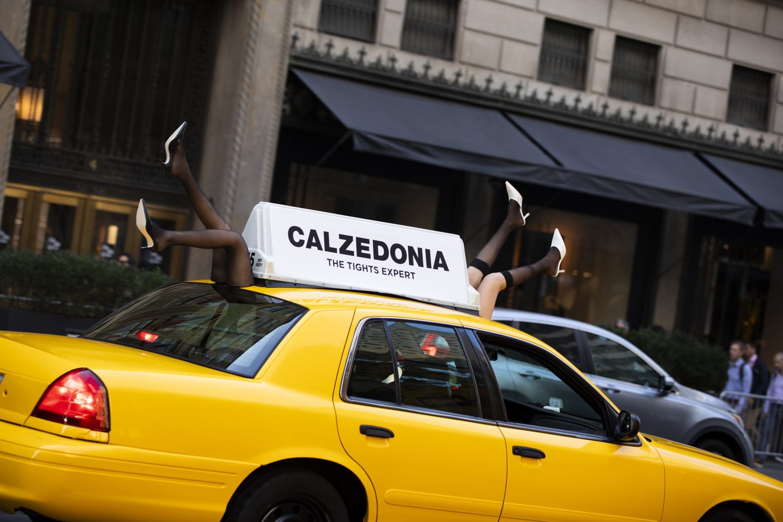 Calzedonia legs-in-tights cab topper Calzedonia-branded vintage NYC yellow cab with legs-in-tights roof topper on a NYC street