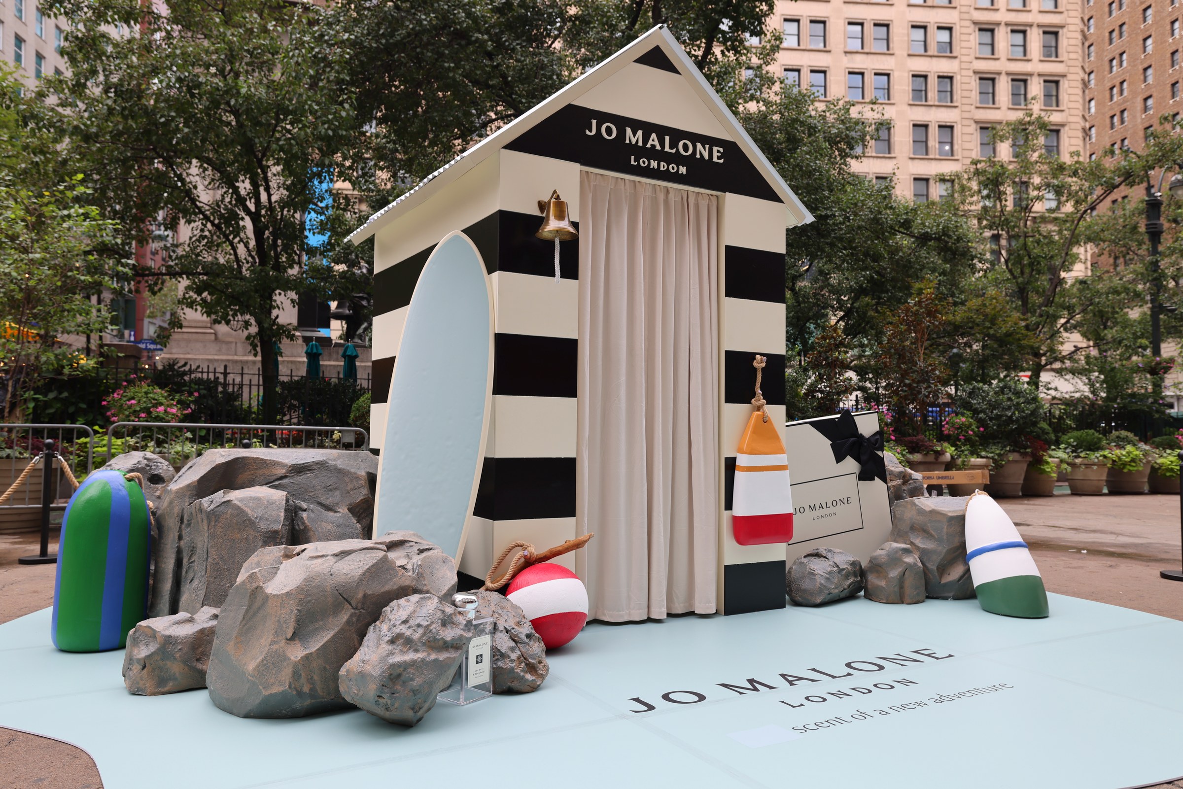Jo Malone London striped beach hut photobooth with carved rocks, buoys and surfboard at Herald Square