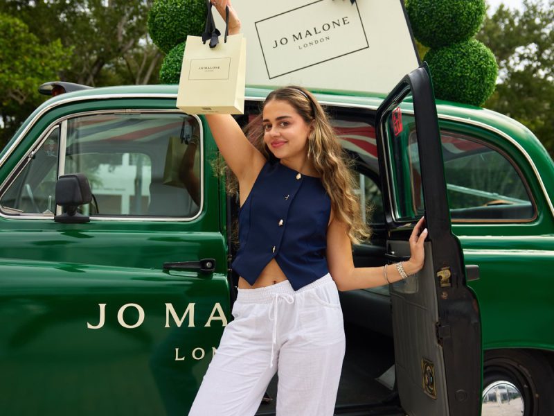 Guest at the Jo Malone London cab Guest with a Jo Malone London bag at the open door of the green London taxi