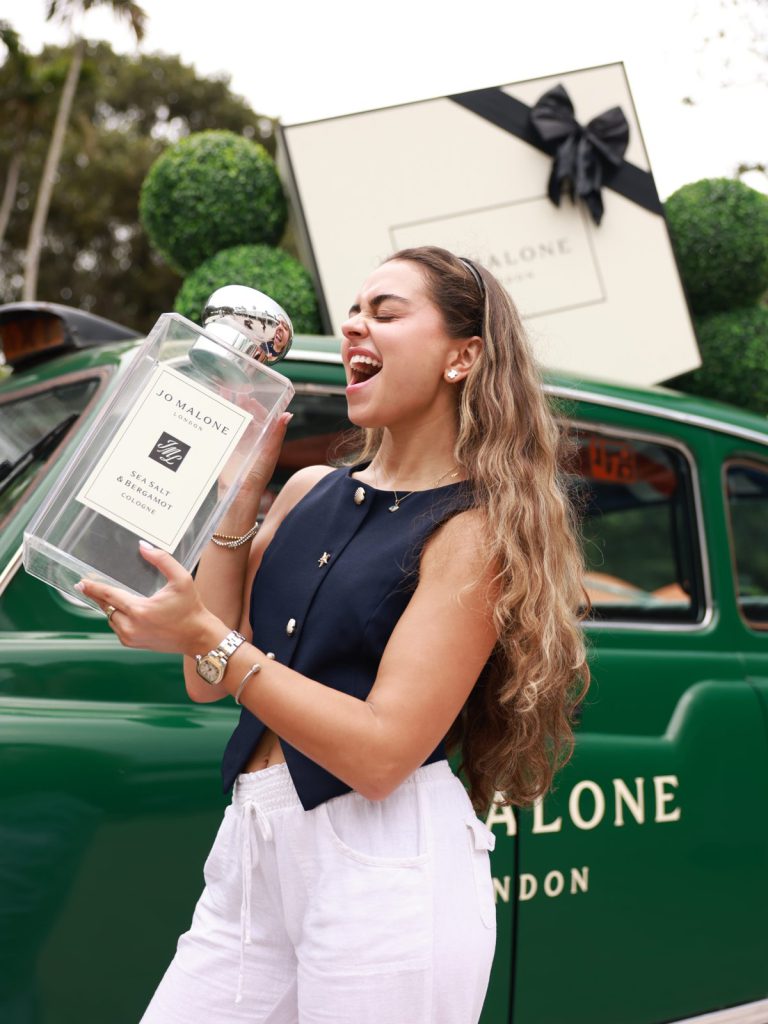 Guest with oversized Jo Malone bottle Guest holding an oversized Jo Malone London bottle beside the green London taxi