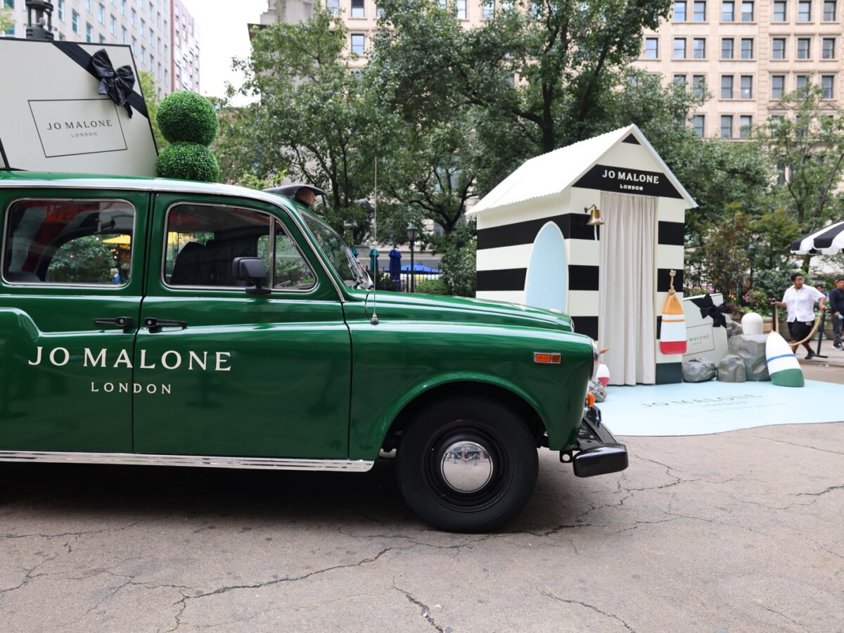 Jo Malone London cab beside striped pop-up Jo Malone London taxi side profile beside the striped pop-up