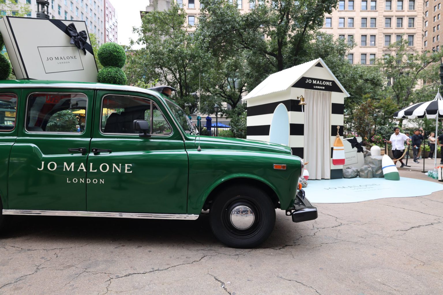 Jo Malone London cab beside striped pop-up Jo Malone London taxi side profile beside the striped pop-up