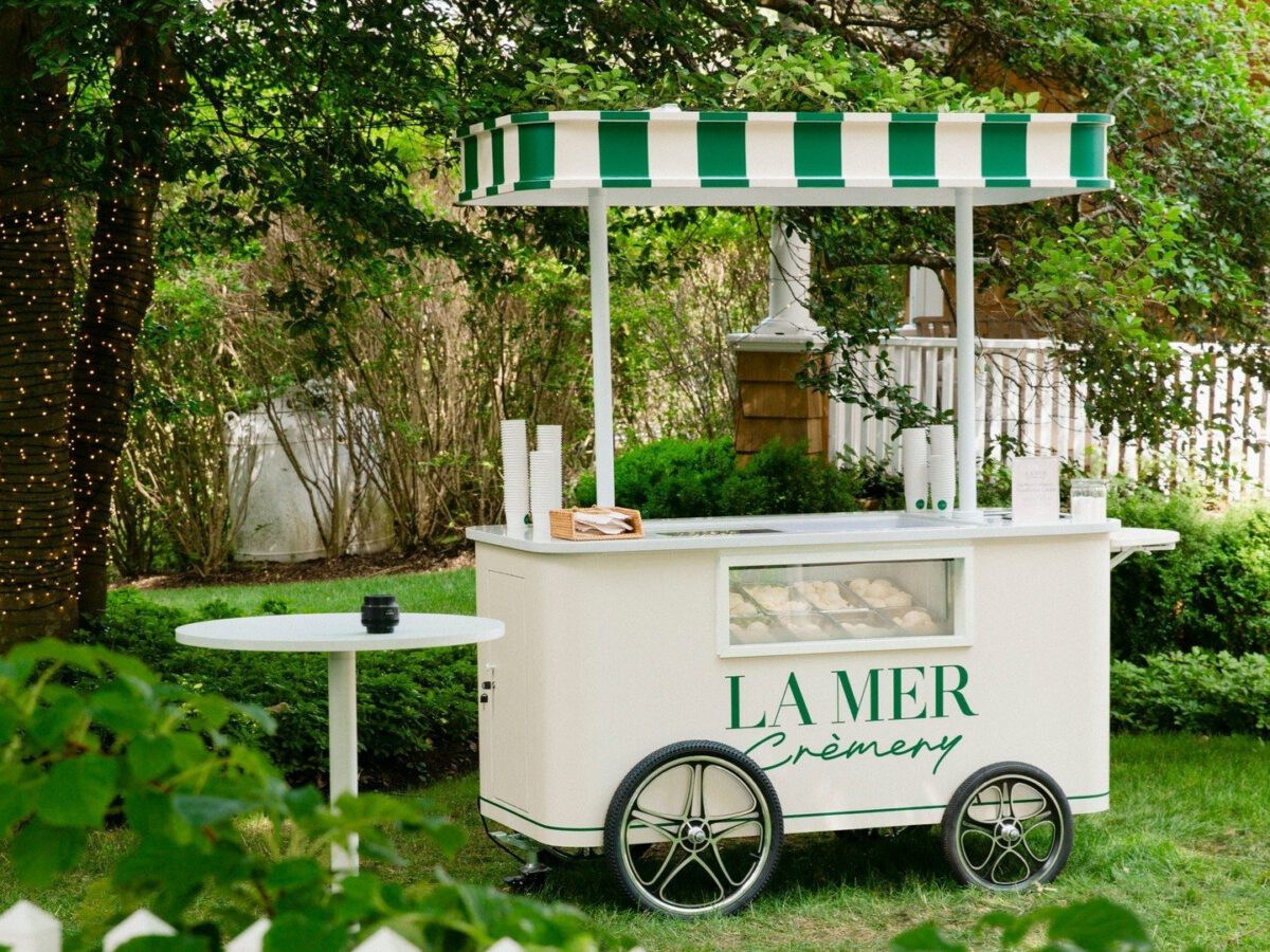 La Mer Cremery sampling cart La Mer Crèmery branded sampling cart with green-and-white striped canopy on a Hamptons lawn